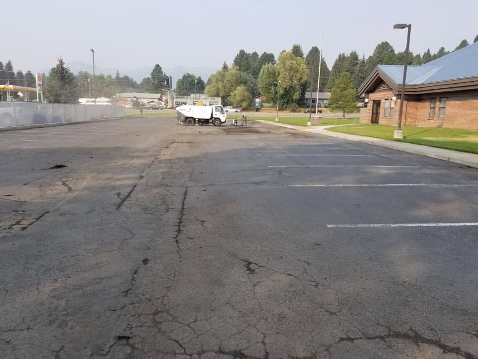 Faded and cracked commercial parking lot before A.A. Sealcoat completed the project